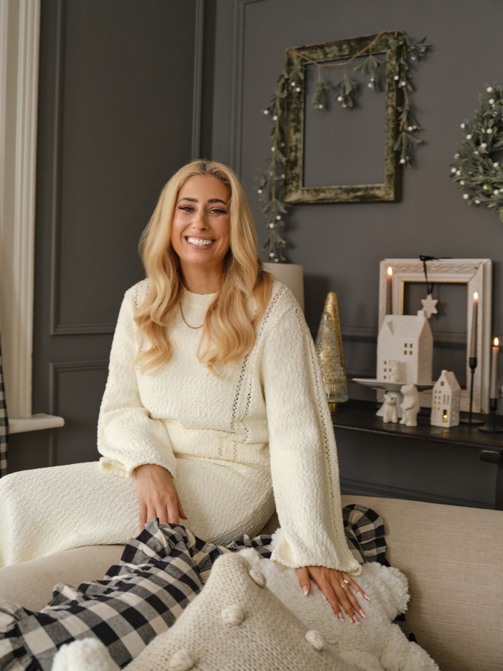 a woman in a white sweater sits on a couch