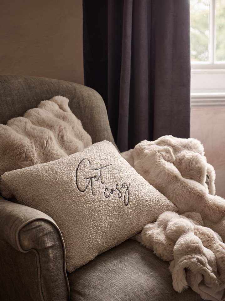 a couch with a pillow that says get cosy on it