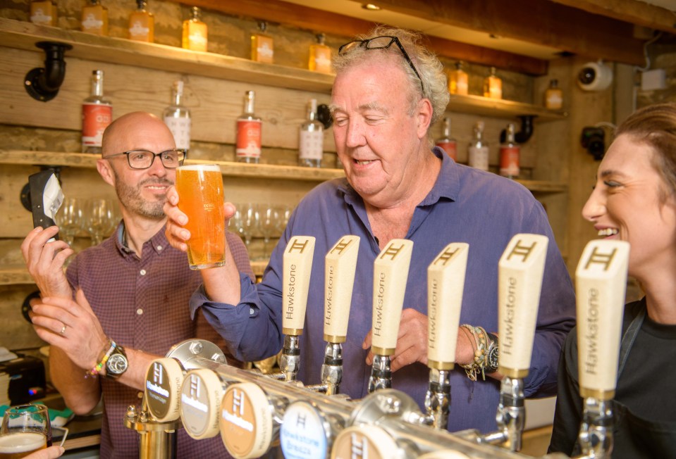 a man is pouring a beer from a tap that says hawkstone