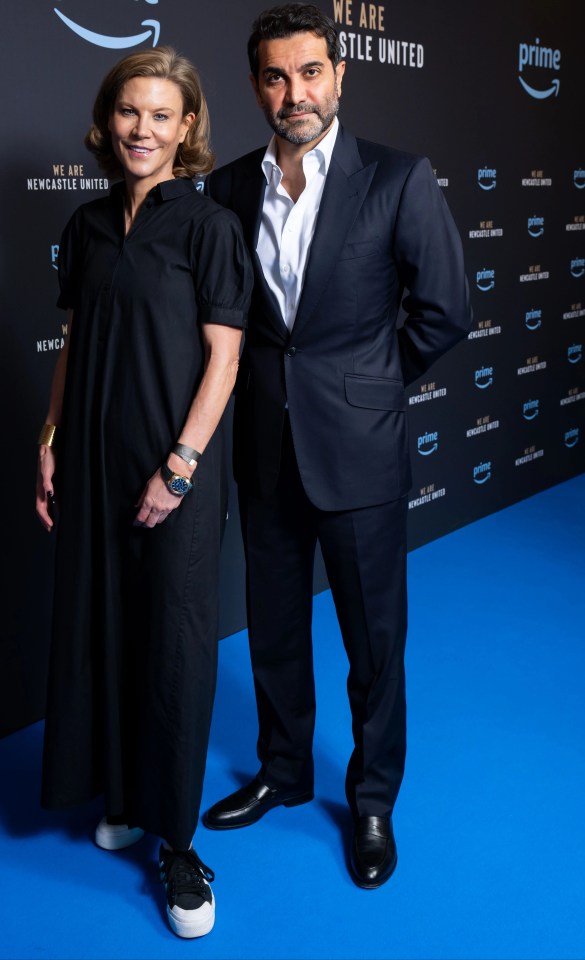 a man and a woman standing on a blue carpet that says prime