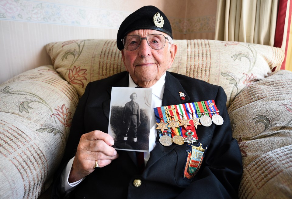 Don Sheppard holding a photo of himself as a young man and wearing his campaign medals at his home in Basildon, Essex