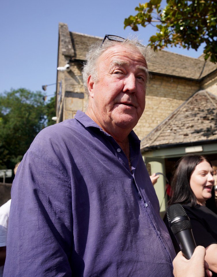 a man in a purple shirt is holding a microphone