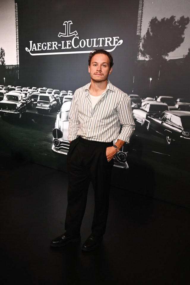 a man stands in front of a jaeger-lecoultre sign