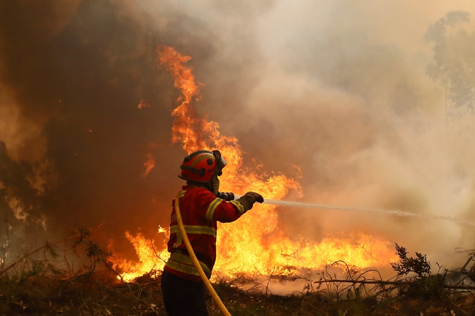 a fireman is spraying water on a large fire