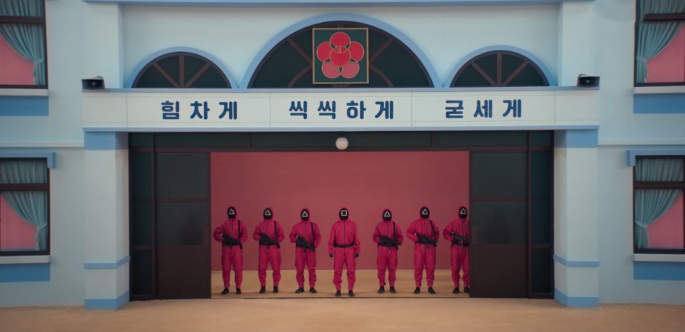 a group of people standing in front of a building with chinese writing on it