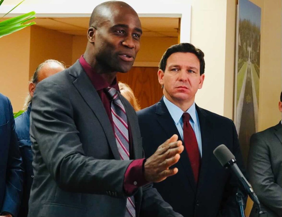 a man in a suit and tie is speaking into a microphone