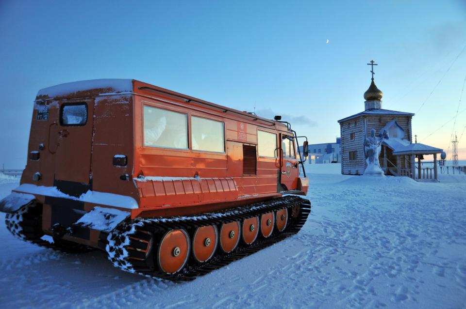 an orange vehicle with a russian flag on the side is parked in the snow