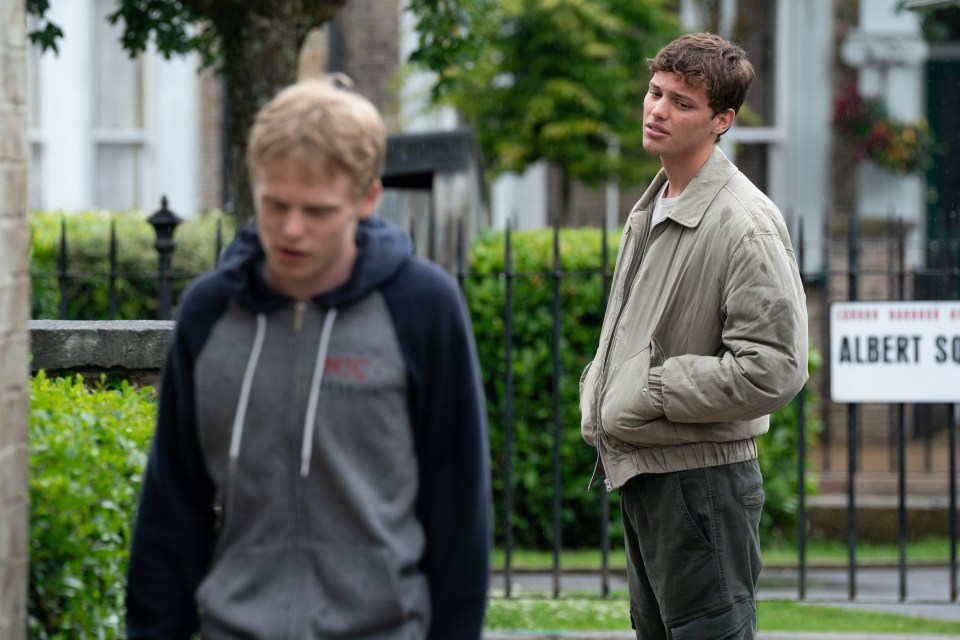 two young men standing in front of a sign that says albert square