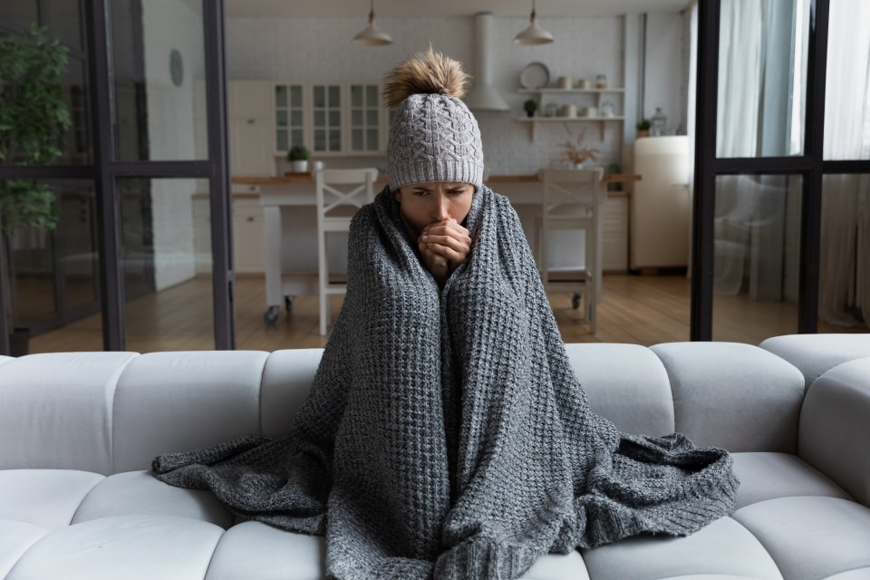 a woman wrapped in a blanket is sitting on a couch