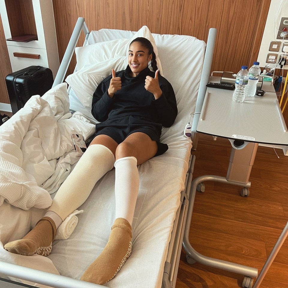 a woman in a hospital bed gives a thumbs up