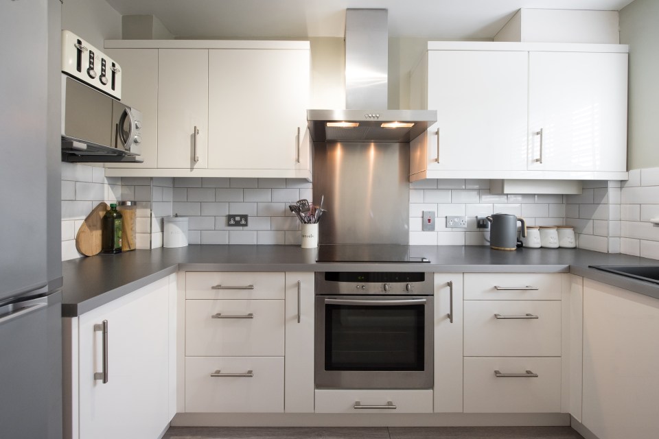 a kitchen with white cabinets and stainless steel appliances