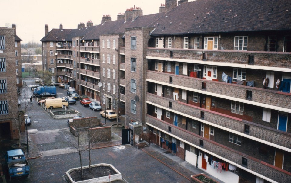 an aerial view of a brick building with a blue van parked in front of it