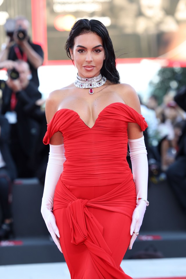 a woman in a red dress and white gloves poses for a picture