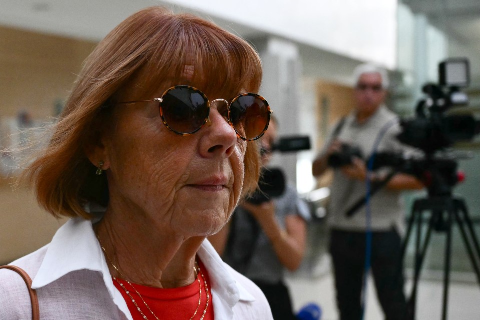 a woman wearing sunglasses stands in front of a camera