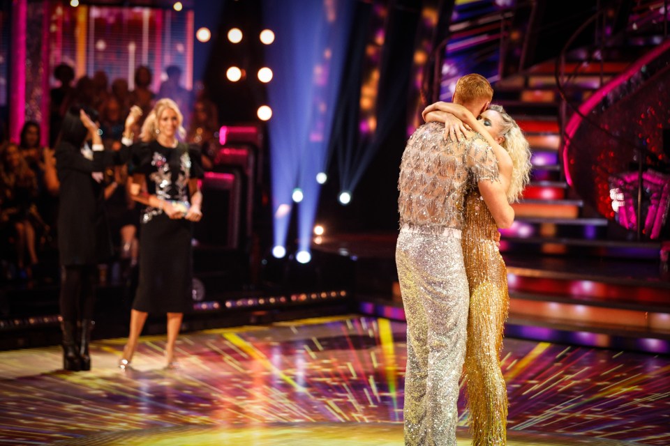 a man and a woman are hugging on a stage