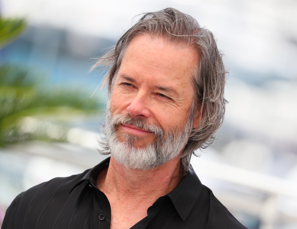 a man with gray hair and a beard is wearing a black shirt