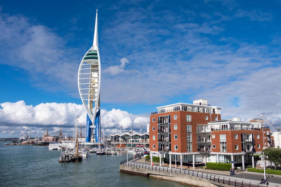 a very tall tower is in the middle of a harbor