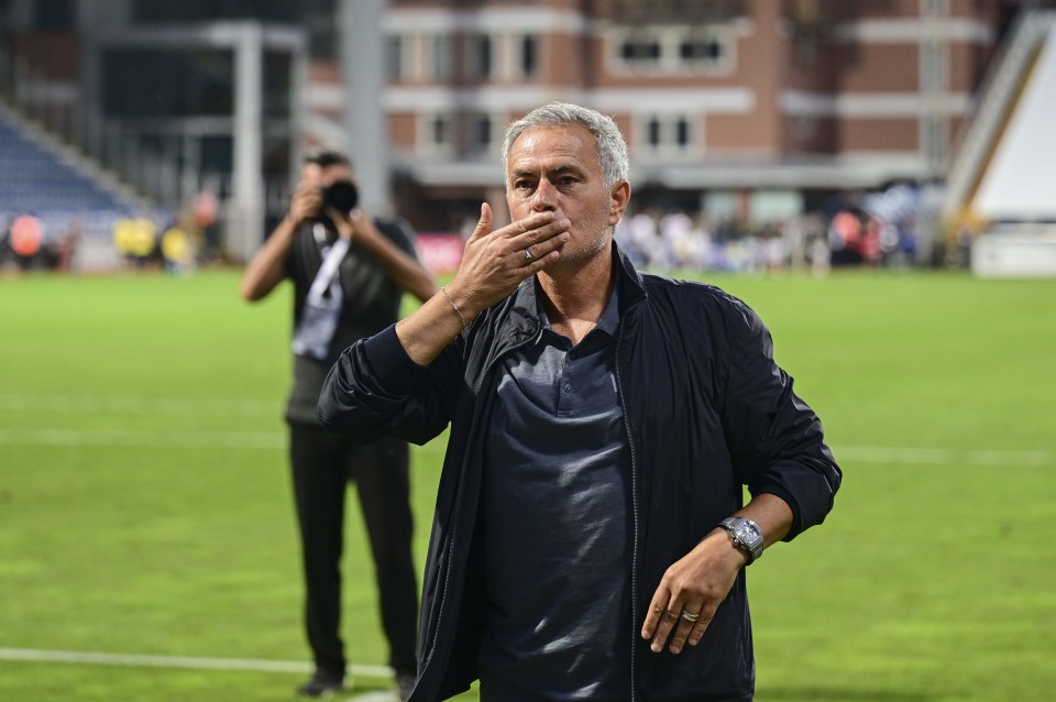 a man covering his mouth with his hand on a soccer field