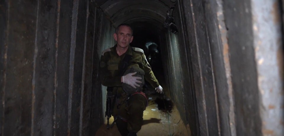 a man in a military uniform is walking through a dark tunnel