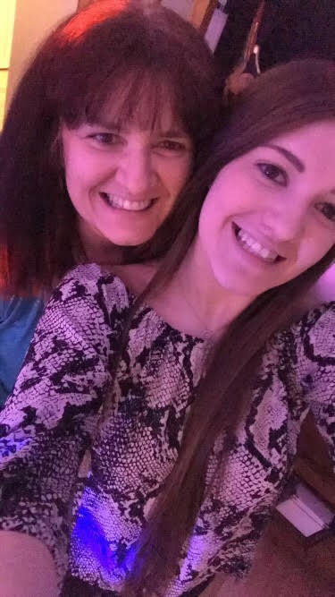 a mother and daughter are posing for a selfie together .