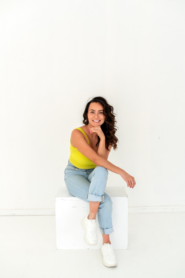 a woman is sitting on a white box with her legs crossed