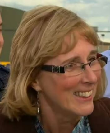 a close up of a woman wearing glasses and smiling .