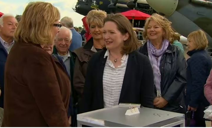 a group of women standing around a box with the letter s on it