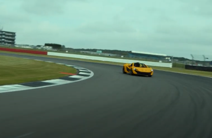 a yellow sports car is driving on a race track