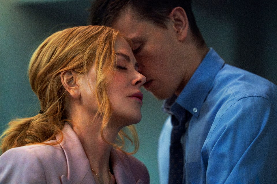 a man in a blue shirt and tie kisses a woman on the forehead