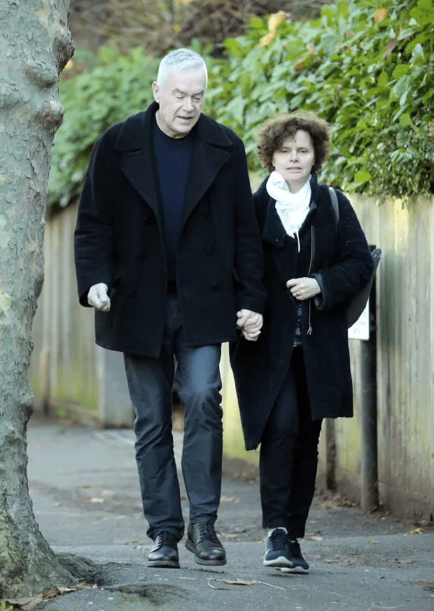 a man and woman walking down a sidewalk holding hands