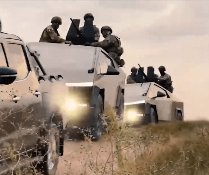 a group of military vehicles are driving through a field