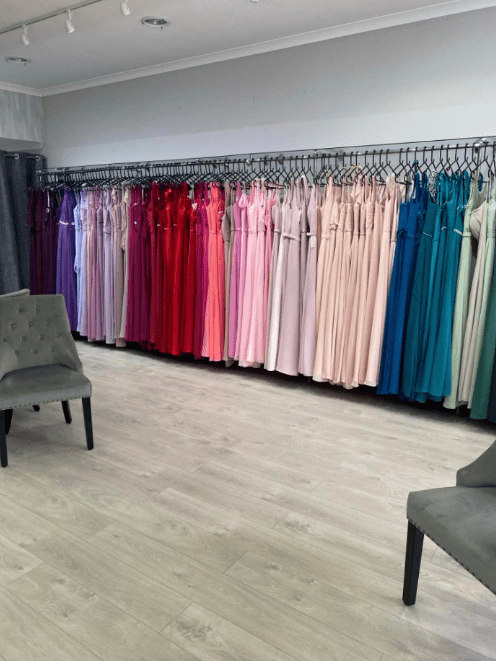 a row of dresses hang on a rack in a store