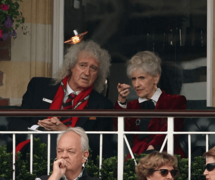 a man with a lanyard that says ' brian ' on it sits next to a woman