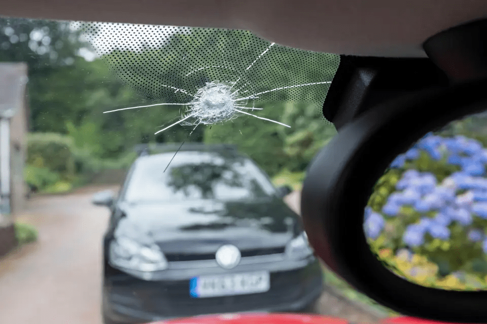 a volkswagen with a broken windshield is parked on the side of the road