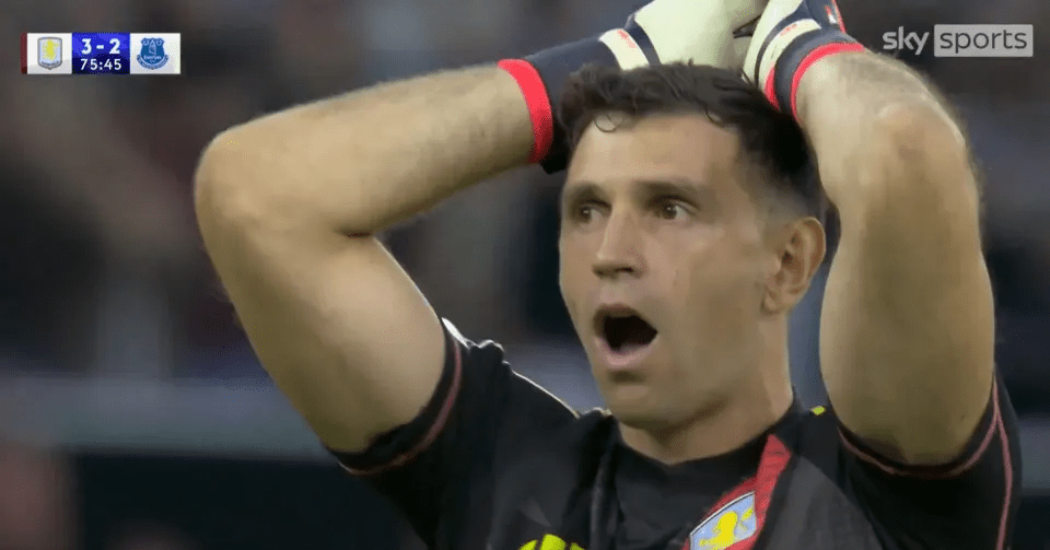 a soccer player holds his hands to his head while watching a game on sky sports