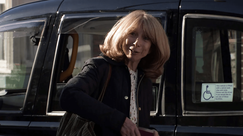 a woman is getting out of a taxi with a handicap sign on the door