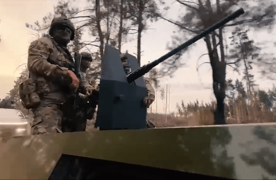 a group of soldiers are standing on top of a military vehicle