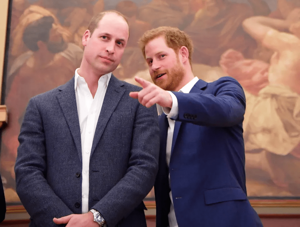 two men in suits are standing next to each other and one is pointing