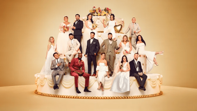 a group of people posing on top of a wedding cake