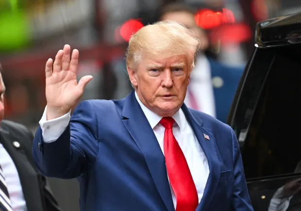 a man in a suit and tie is waving his hand