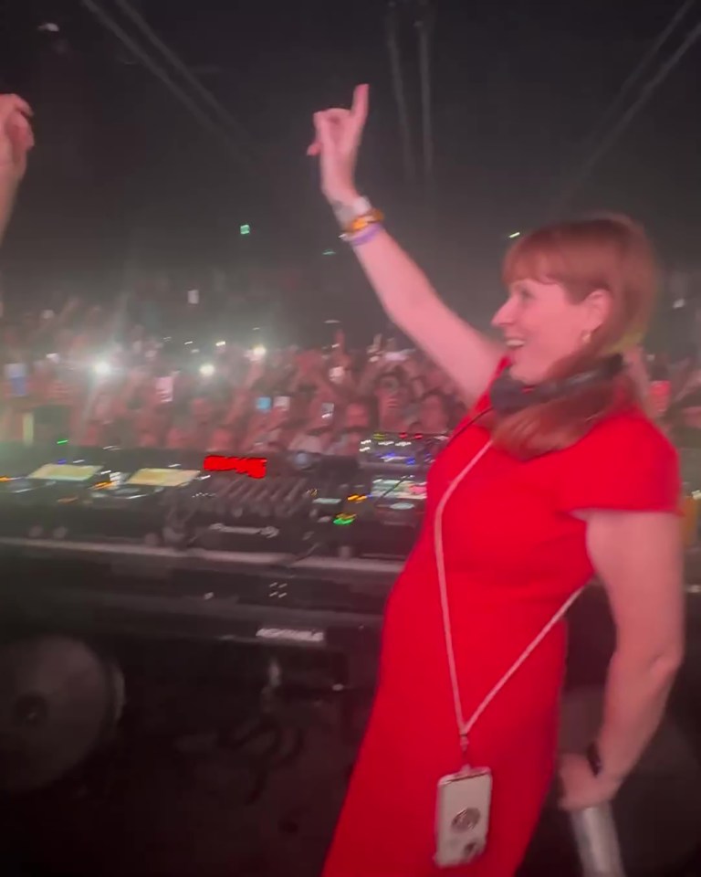 a woman in a red dress stands in front of a pioneer dj machine