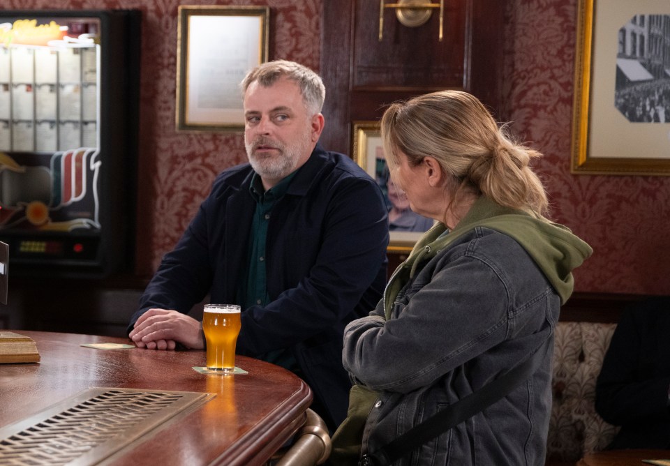 a man and a woman sit at a bar with a glass of beer