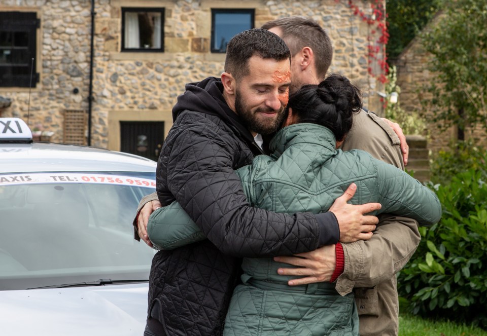 a man and woman hugging in front of a taxi