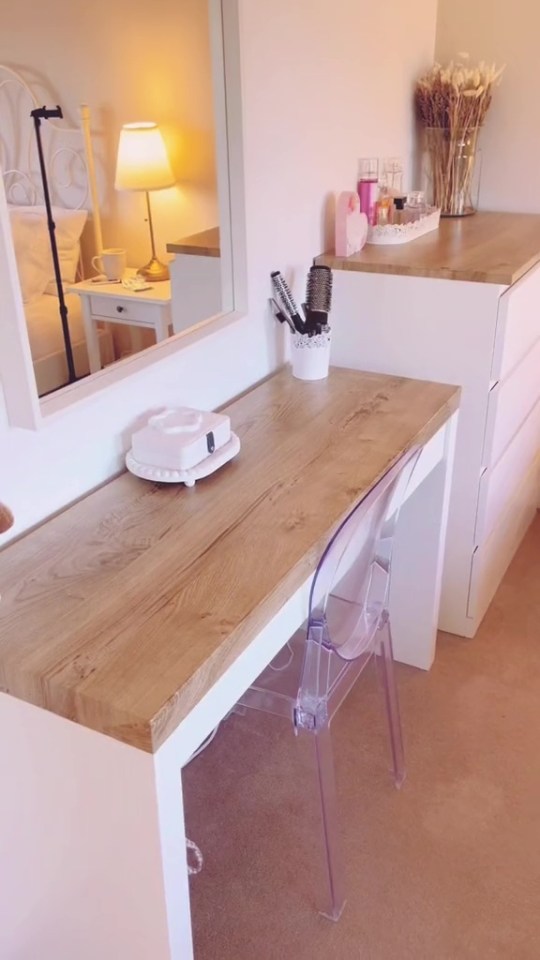 a wooden desk with a clear chair in front of it