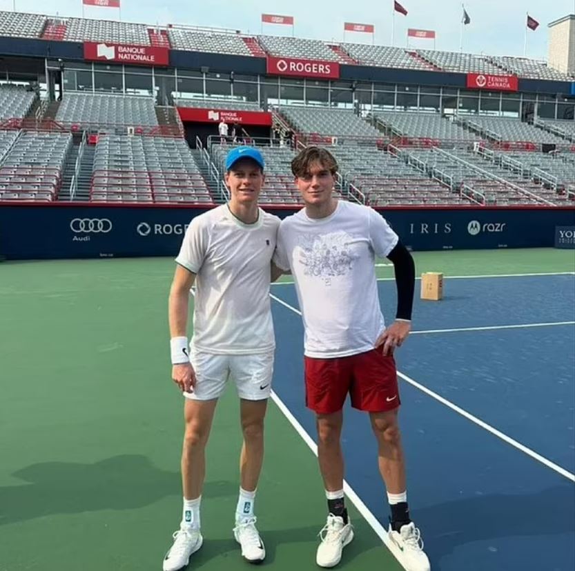 two tennis players are posing for a picture on a tennis court sponsored by rogers