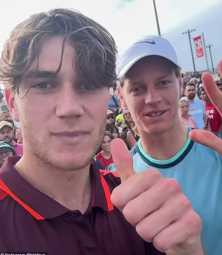 two men are posing for a picture and one is wearing a nike hat