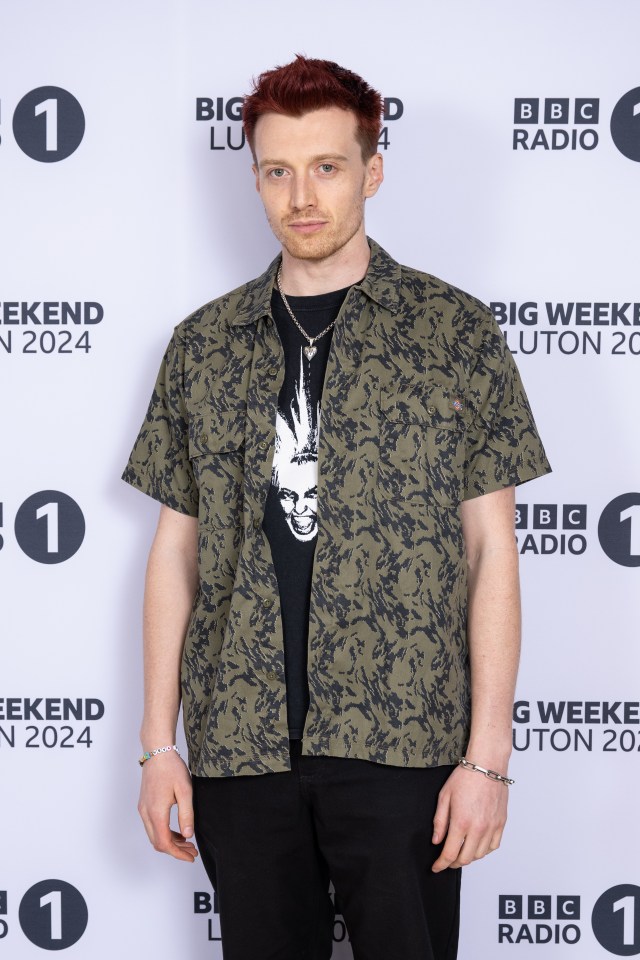 a man stands in front of a bbc radio 1 sign