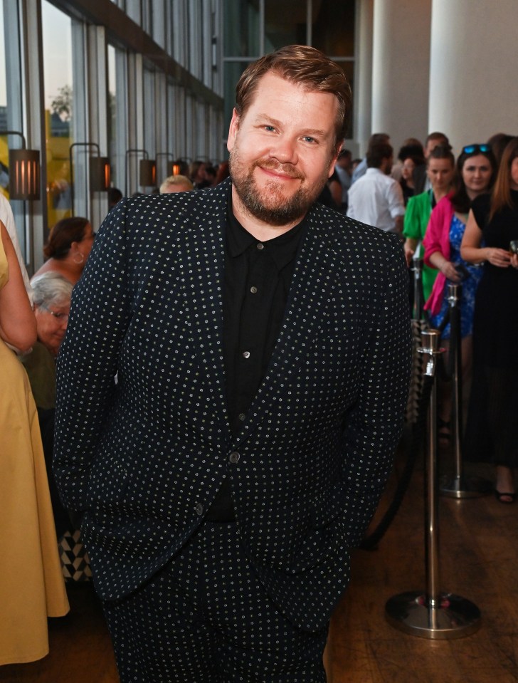 a man in a suit stands in front of a crowd of people