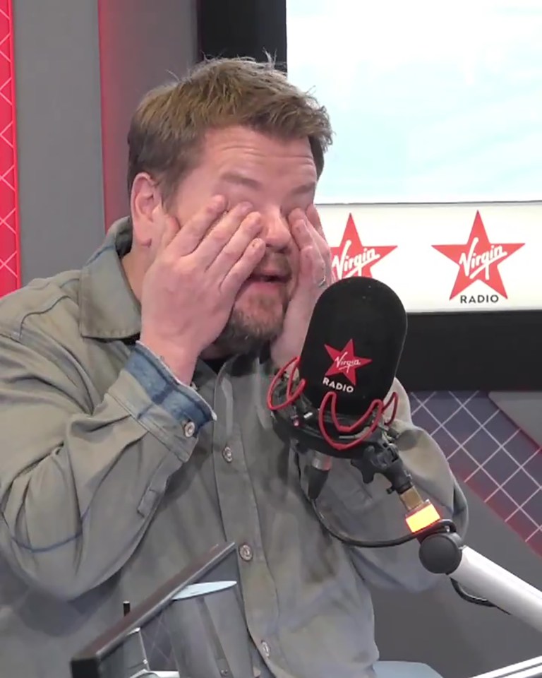 a man covering his eyes in front of a virgin radio microphone