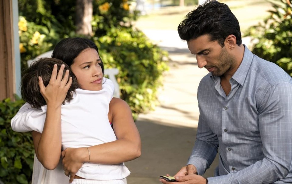 a man holding a cell phone while a woman holds a child